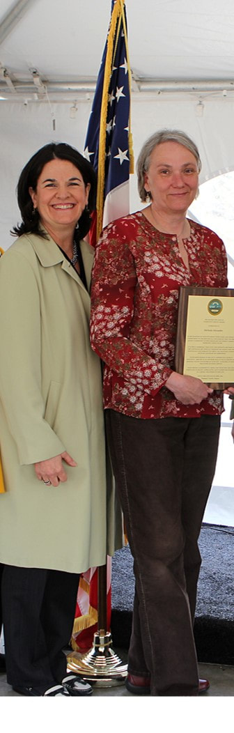 Melinda Alexander, QCAP Food Center Coordinator (Right) pictured with Beth Ann Strollo, QCAP CEO (left), holding the Mayor's Annual Community Service Award for 2014. 